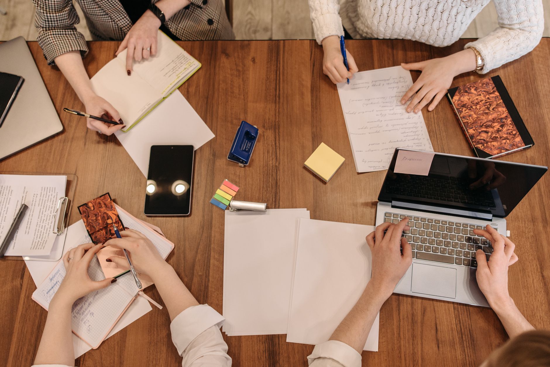 People working around a table with notebooks and computers
